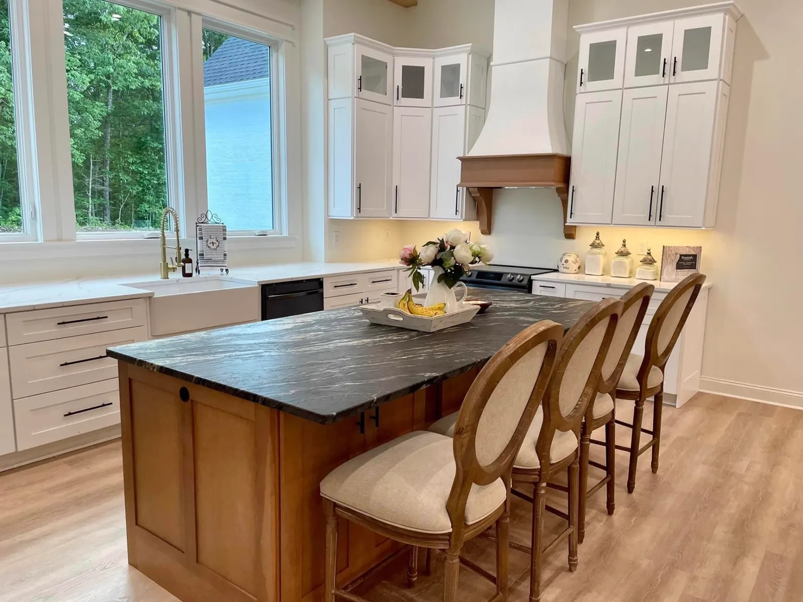 Custom kitchen with stained wood hood and dark stone island